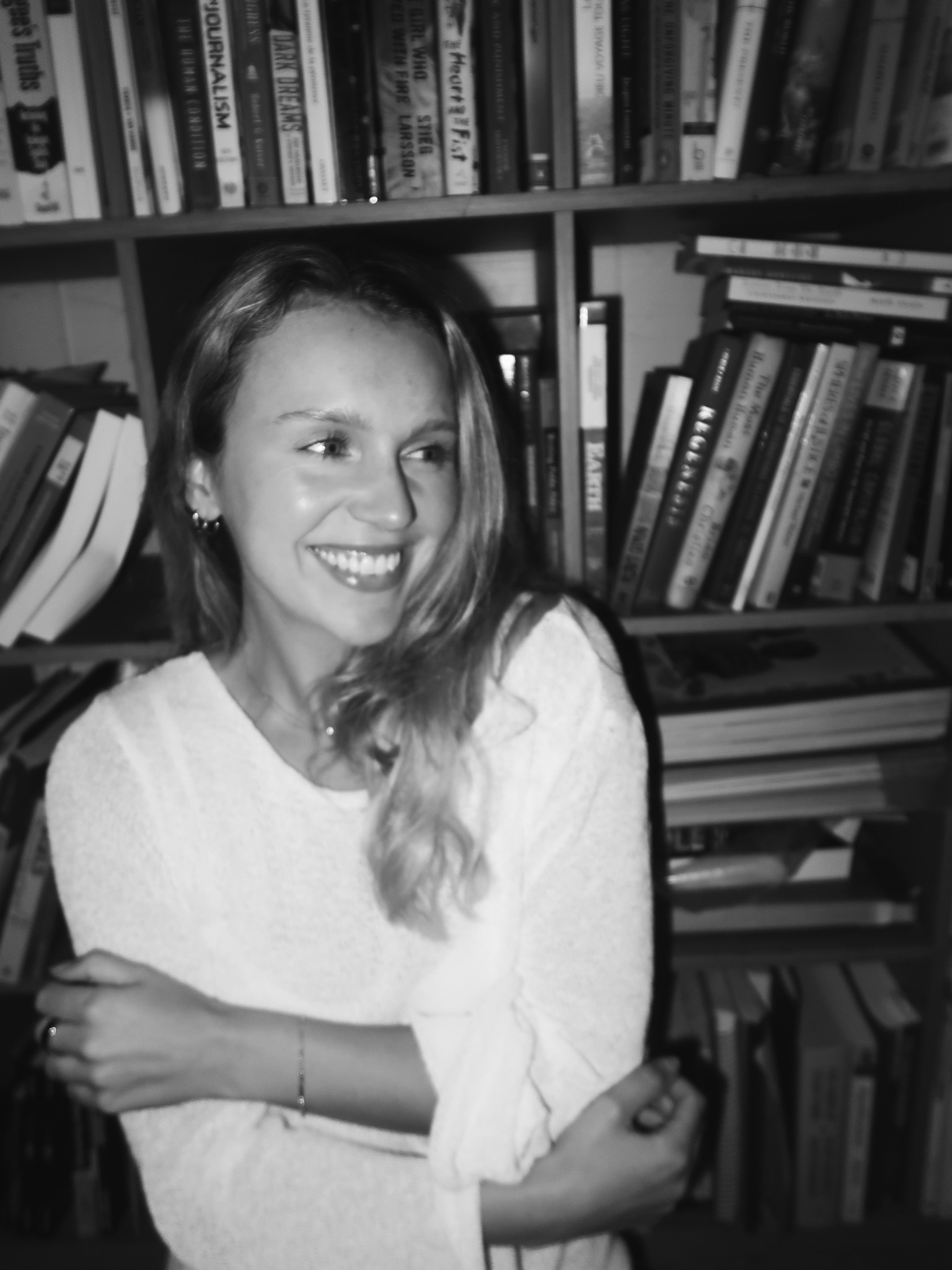 Sylvia Moulthrop smiling in front of a bookshelf